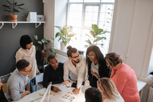 Team steht an einem Tisch und diskutiert